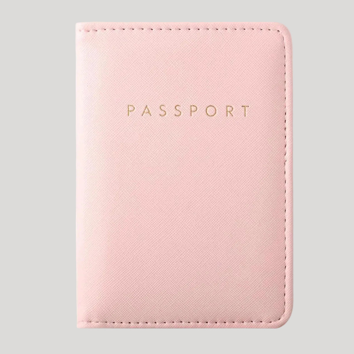 A light pink faux leather passport holder with gold embossed 'PASSPORT' text, shown on a plain white background.