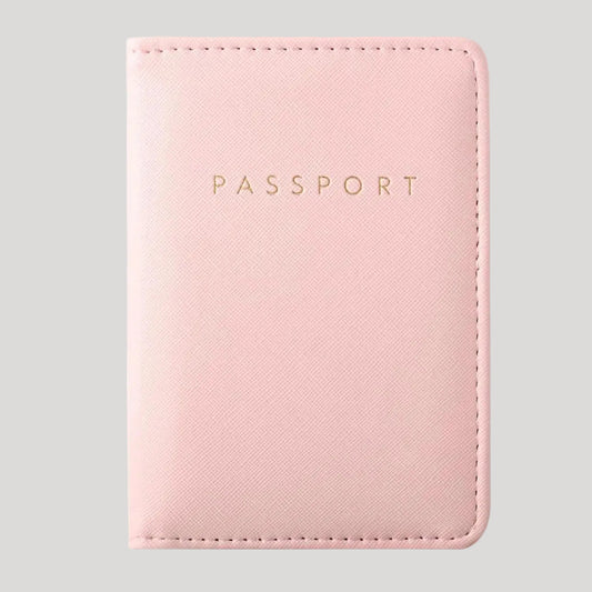 A light pink faux leather passport holder with gold embossed 'PASSPORT' text, shown on a plain white background.